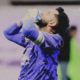Soccer goalkeeper in a blue kit with gloves, hands on head in disbelief or frustration on the field