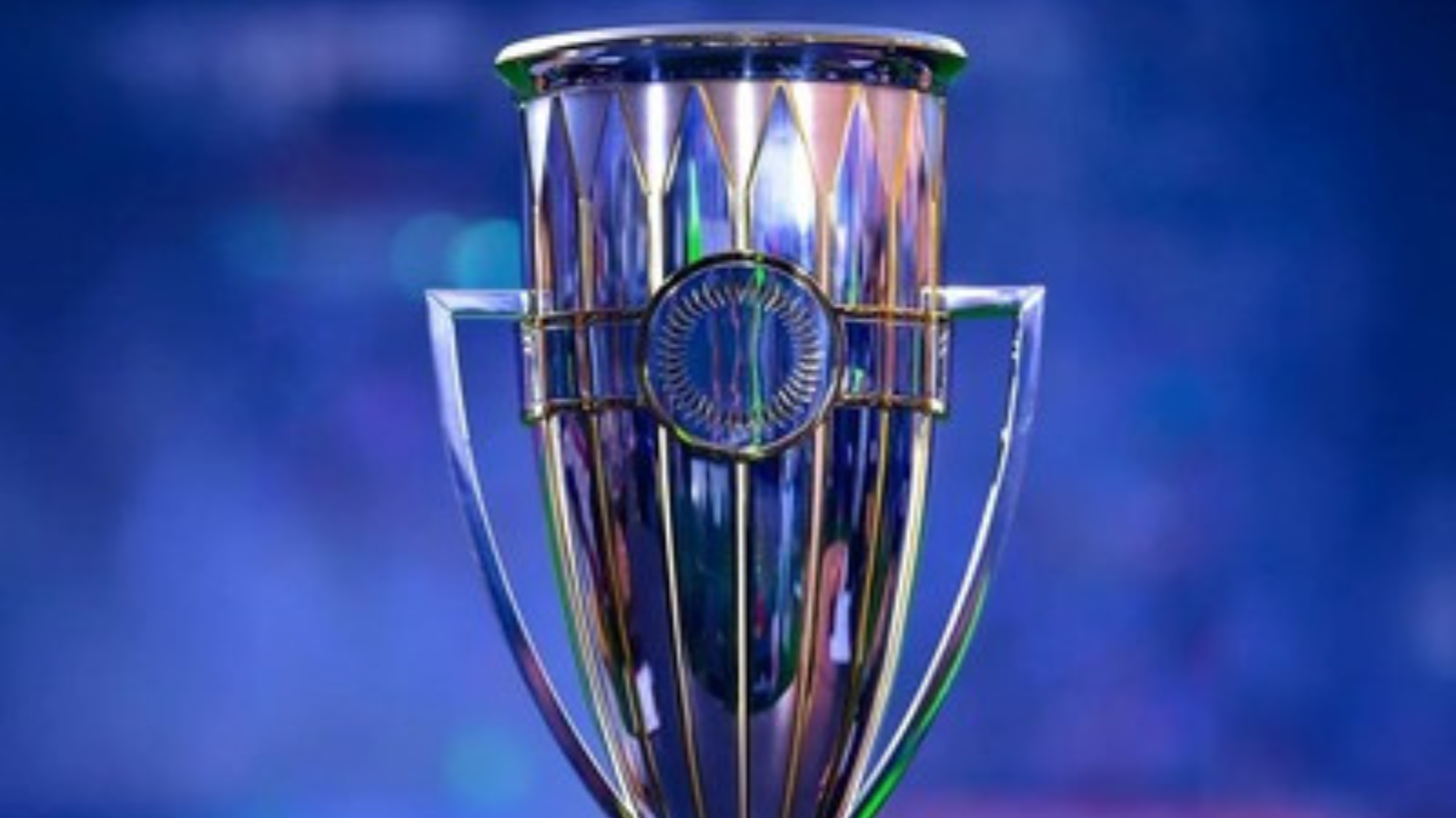 Shiny silver trophy with blue background, central circular medallion and two handles on sides.