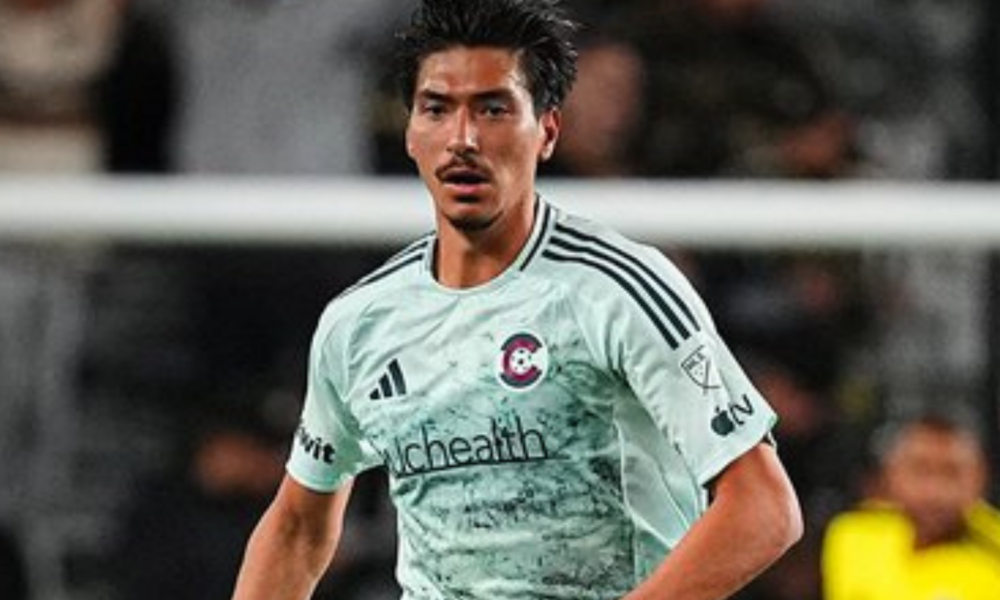 Soccer player in a pale green jersey with a Chicago club crest, running on the field during a match.