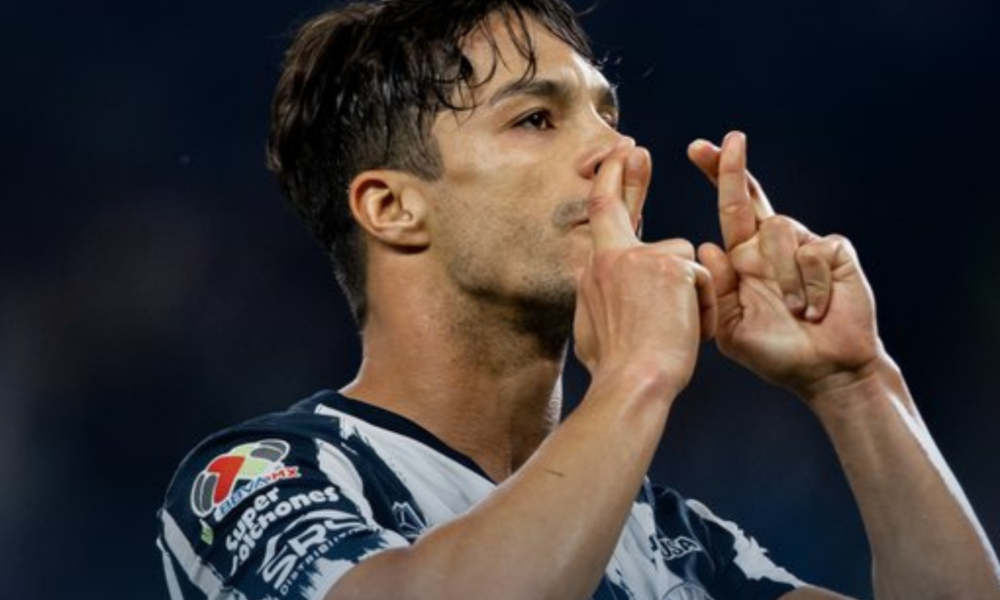 Athlete in a striped jersey kissing his fingers in a celebratory gesture on the field.