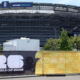 Stadium under construction with a FIFA World Cup 2026 banner and a blue 'We are New York New Jersey' sign on top.