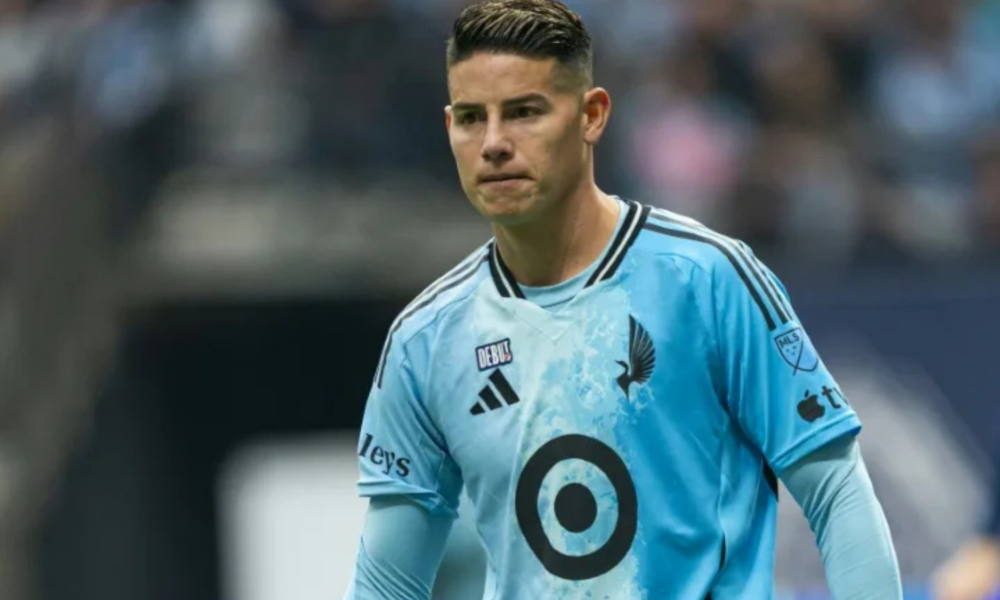 Soccer player in a light blue jersey on the field, looking focused during a match.