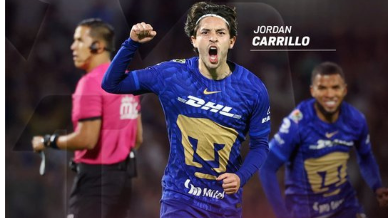 Soccer player Jordan Carrillo in blue jersey celebrates a goal, fist raised; teammate behind and a pink referee shirt visible left.