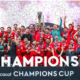 Soccer team in red celebrates winning the CONCACAF Champions Cup, lifting the trophy amid confetti and cheers.