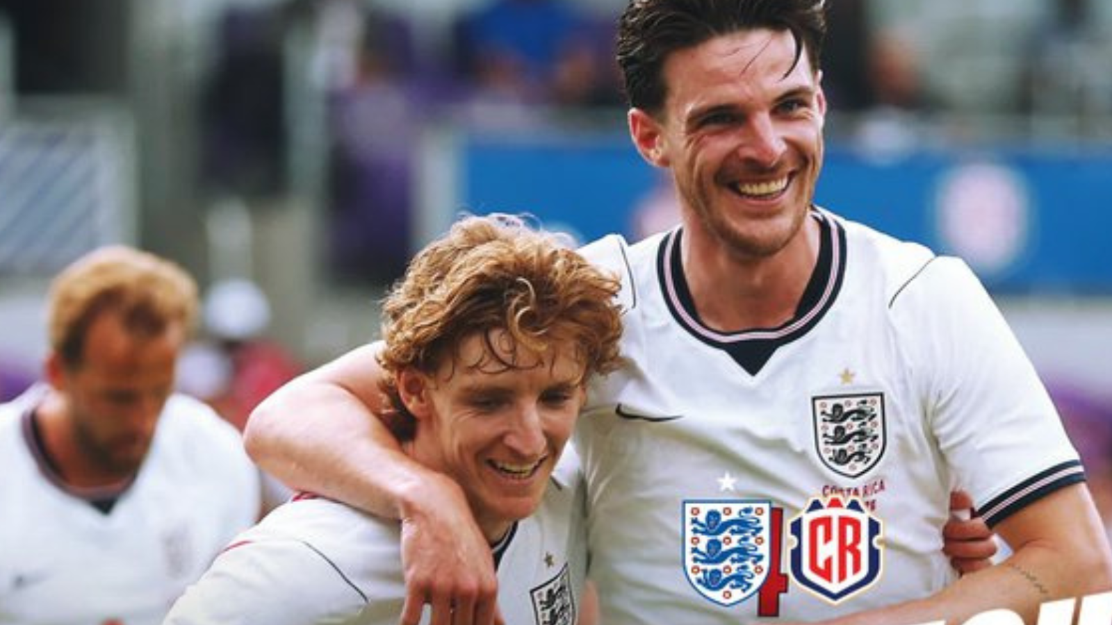 Two England footballers celebrate, arms around each other, smiling on the pitch after a game.