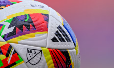 Close-up of a colorful MLS soccer ball with Adidas logo and textured panels.
