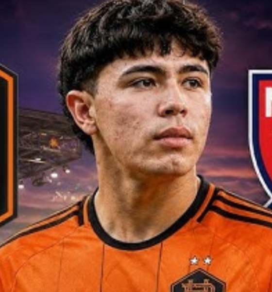 Portrait of a young soccer player in an orange Houston Dynamo FC jersey, with MLS logo in the background.